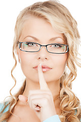 Image showing woman wearing eyeglasses with finger on her lips