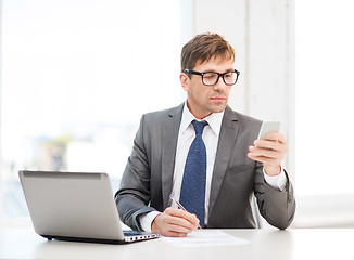 Image showing businessman working with laptop and smartphone