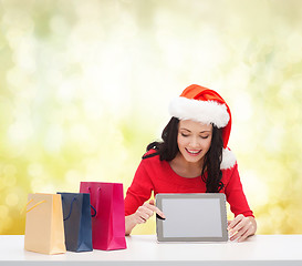 Image showing smiling woman in santa helper hat with tablet pc