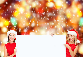 Image showing women in santa helper hats with blank white board