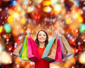 Image showing woman in red dress with colorful shopping bags