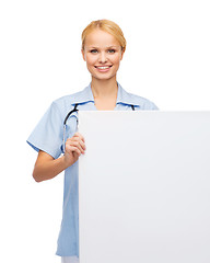 Image showing smiling female doctor or nurse with blank board