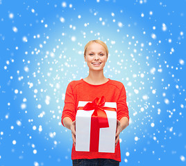 Image showing smiling woman in red sweater with gift box