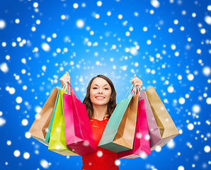 Image showing woman in red dress with colorful shopping bags