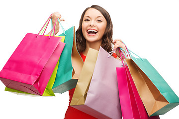 Image showing woman in red dress with colorful shopping bags