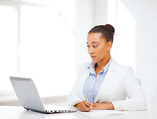 Image showing african businesswoman writing something