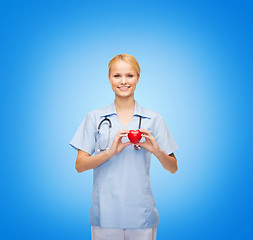 Image showing smiling female doctor or nurse with heart