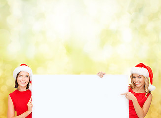 Image showing women in santa helper hats with blank white board