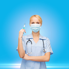 Image showing female doctor or nurse in mask holding syringe