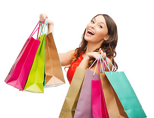 Image showing woman in red dress with colorful shopping bags