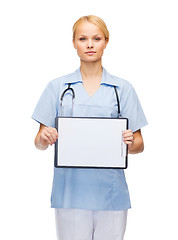 Image showing smiling female doctor or nurse with sclipboard