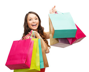 Image showing woman in red dress with colorful shopping bags