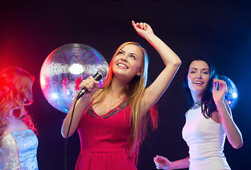 Image showing three smiling women dancing and singing karaoke