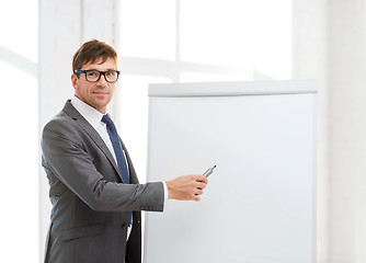 Image showing businessman pointing to flip board in office