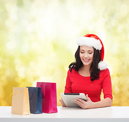 Image showing smiling woman with shopping bags and tablet pc