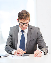 Image showing businessman with papers and calculator