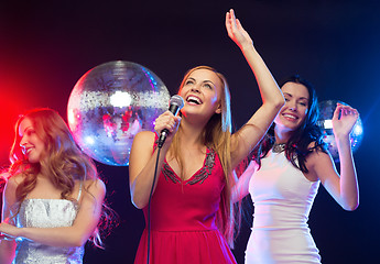 Image showing three smiling women dancing and singing karaoke