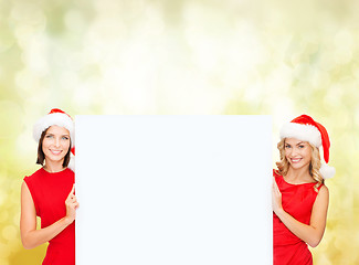 Image showing women in santa helper hats with blank white board