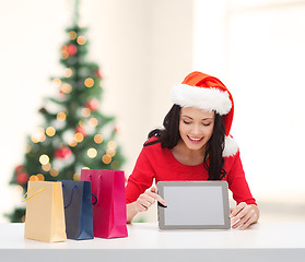 Image showing smiling woman in santa helper hat with tablet pc