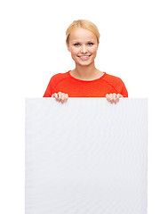 Image showing smiling woman in sweater with blank white board