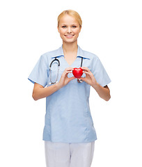 Image showing smiling female doctor or nurse with heart