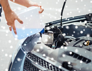 Image showing man filling windscreen water tank