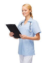 Image showing smiling female doctor or nurse with clipboard