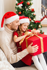 Image showing smiling father and daughter opening gift box