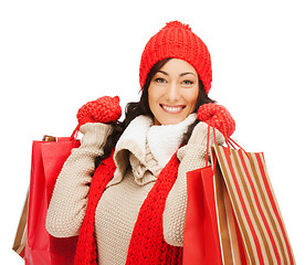 Image showing smiling woman in warm clothers with shopping bags