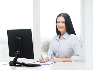 Image showing smiling businesswoman or student studying