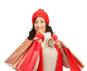 Image showing smiling woman in warm clothers with shopping bags