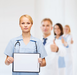 Image showing smiling female doctor or nurse with sclipboard