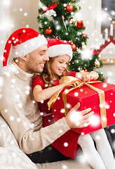 Image showing smiling father and daughter opening gift box