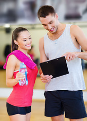 Image showing smiling male trainer with woman in the gym