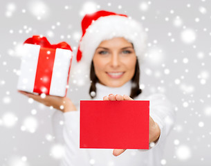 Image showing smiling woman in santa helper hat with postcard