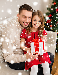 Image showing smiling father and daughter holding gift box