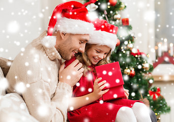 Image showing smiling father and daughter opening gift box