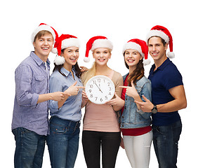 Image showing group of smiling students with clock showing 12