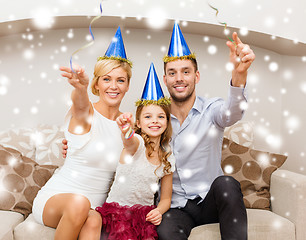 Image showing happy family in blue hats throwing serpentine