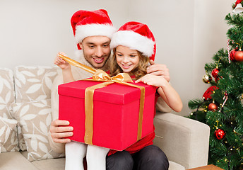 Image showing smiling father and daughter opening gift box