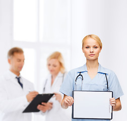 Image showing smiling female doctor or nurse with sclipboard