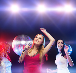 Image showing three smiling women dancing and singing karaoke