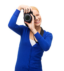 Image showing smiling woman taking picture with digital camera