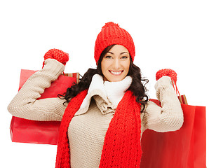 Image showing smiling woman in warm clothers with shopping bags