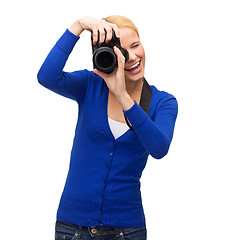 Image showing smiling woman taking picture with digital camera