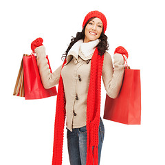 Image showing smiling woman in warm clothers with shopping bags