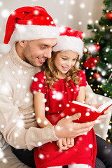 Image showing smiling father and daughter reading book