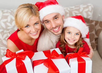 Image showing smiling family holding many gift boxes