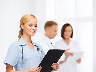 Image showing smiling female doctor or nurse with clipboard