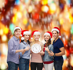 Image showing group of smiling students with clock showing 12